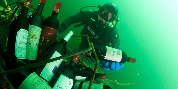 Thợ lặn với những chai rượu vang được ủ dưới đáy biển